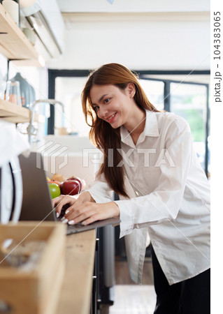 Portrait of a young cheerful asian woman at kitchen room with healthy raw food. Vegetarianism, wellbeing and healthy lifestyle concept 104383065