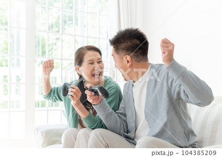 家でゲームをする高齢者夫婦 104385209