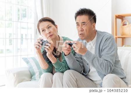家でゲームをする高齢者夫婦 家でゲームをする高齢者夫婦 104385210