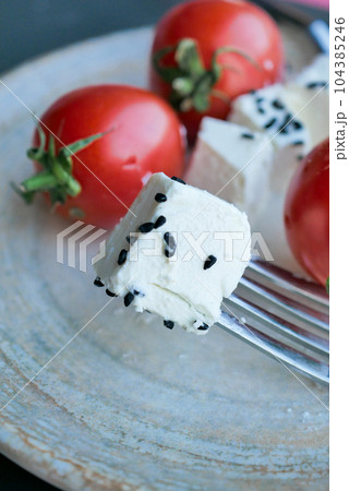 greek feta cubes with tomato diced soft cheese on plate  104385246