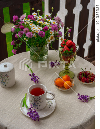 Morning tea with flowers and fruits on the terrace of a country house. 104385385