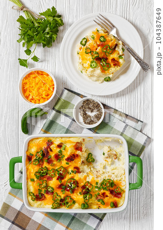 Loaded smashed potatoes with cheese, bacon, cream 104387649