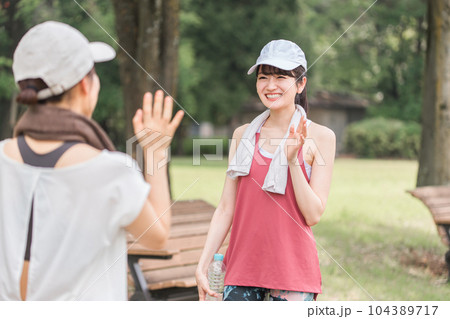 公園で運動・トレーニング・ウォーキングする女性（手を振る） 104389717