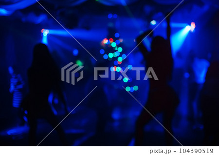 blurred silhouettes of dancing people at a nightclub blurred silhouettes of dancing people at a nightclub 104390519
