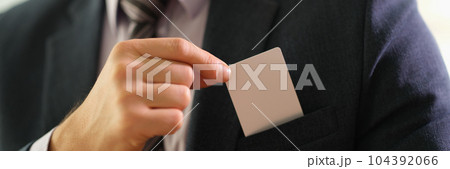 Businessman taking out business card from his jacket pocket closeup 104392066