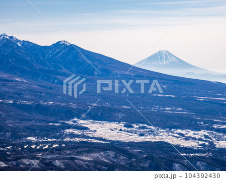凍てつく霧ケ峰にて快晴の青空にただよう雲と北アルプスを望む 凍てつく霧ケ峰にて快晴の青空にただよう雲と北アルプスを望む 104392430
