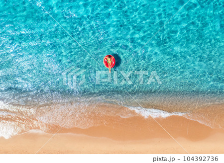 Beautiful seascape with woman with red swim ring in blue sea 104392736
