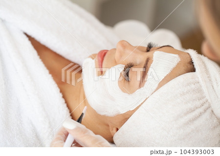 Beautiful african woman getting face massage in beauty spa Beautiful african woman getting face massage in beauty spa 104393003