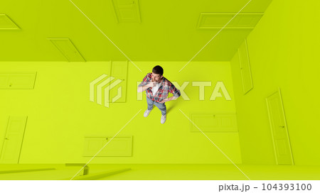 Conceptual design. Man with doubtful, thoughtful face standing around many closed doors over green background. Choice Conceptual design. Man with doubtful, thoughtful face standing around many closed doors over green background. Choice 104393100