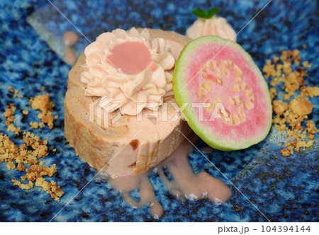 Guava Roll Cake on blue plate on light background with ripe guava fruit 104394144