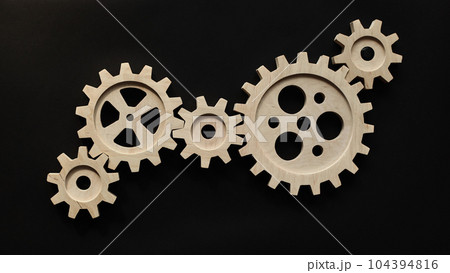 Wooden mechanisms on a black background. Black chalk board. Wooden mechanisms on a black background. Black chalk board. 104394816
