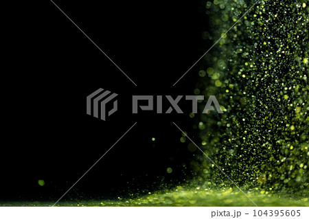 Explosion metallic green glitter sparkle. Green Glitter powder spark blink celebrate, blur foil explode in air, fly throw green glitters particle. Black background isolated, selective focus Blur bokeh 104395605