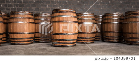 Wooden barrels in cellar backgound, empty space on barrel for advertising. Old Wooden barrels with wine in wine vault. wide banner Wooden barrels in cellar backgound, empty space on barrel for advertising. Old Wooden barrels with wine in wine vault. wide banner 104399701