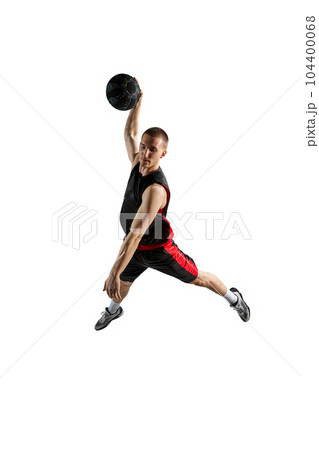 Slam dunk. Full-length dynamic image of young man, basketball player in jump with ball isolated against white background 104400068