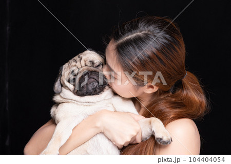 Asian woman hugging dog pud breed with love happiness emotional isolated on black background Asian woman hugging dog pud breed with love happiness emotional isolated on black background 104404054