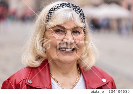 Happy senior woman smiling looking away dreaming, resting, good news, feel satisfied in city street 104404659