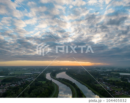 Aerial view of a colorful dramatic sunrise sky over the river Nete in Duffel, Belgium. River with Aerial view of a colorful dramatic sunrise sky over the river Nete in Duffel, Belgium. River with 104405032
