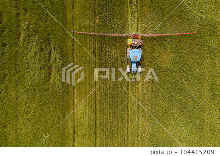 Tractor spraying agricultural fields Tractor spraying agricultural fields 104405209