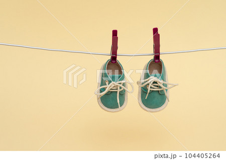 Children's sneakers hanging on a clothesline. Newborn concept 104405264