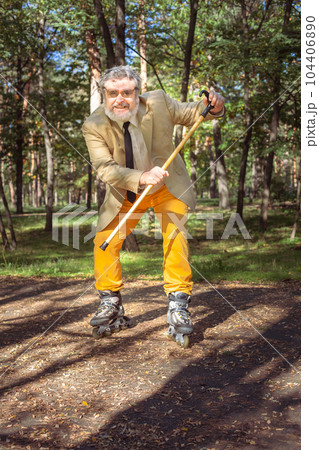 Funny old man on roller skates and walking stick. 104406890