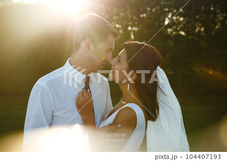 Lovely wedding couple at sunset. Bride, groom in wedding attire with bouquet of flowers. Romantic. Lovely wedding couple at sunset. Bride, groom in wedding attire with bouquet of flowers. Romantic. 104407193