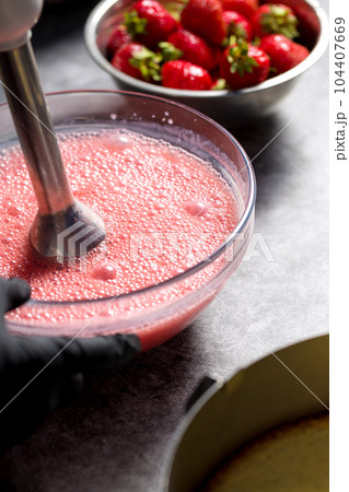 Beat strawberries with sugar in a blender 104407669
