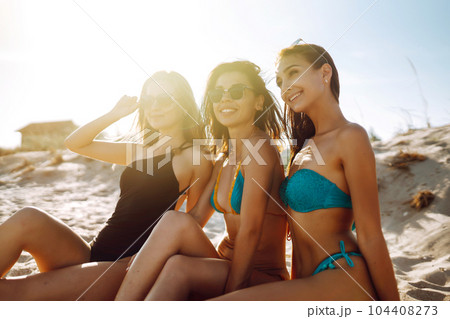 Three beautiful girls on the beach at sunset. Vacation time laughing and smiling. Three beautiful girls on the beach at sunset. Vacation time laughing and smiling. 104408273