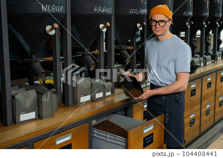 Barista preparing coffee, coffeemaker pouring beams for brewing energy beverage. Barista preparing coffee, coffeemaker pouring beams for brewing energy beverage. 104408441