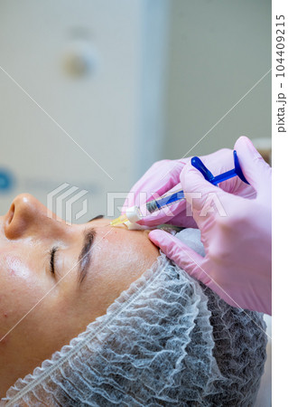 Face injections to woman with skin problems, beauty treatment in cosmetology clinic. Face injections to woman with skin problems, beauty treatment in cosmetology clinic. 104409215