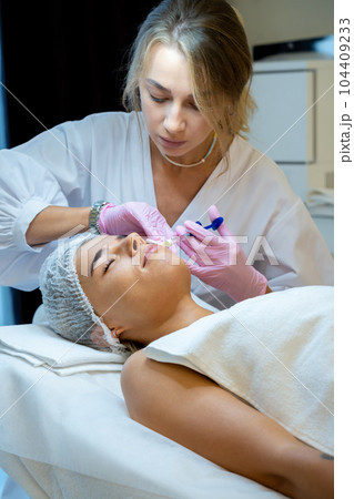 Cosmetology for young female, beautician doctor making injection to face, prp ttherapy. 104409233