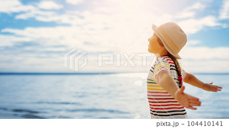 Girl standing on the beach with closed eyes. 104410141