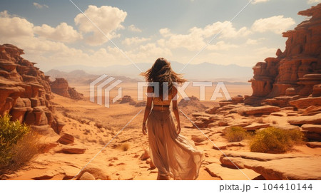 Woman standing alone looking at the desert. 104410144