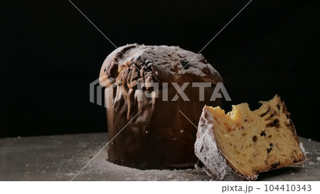 Panettone with dried fruits on black background, selective focus. Panettone with dried fruits on black background, selective focus. 104410343