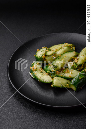 Delicious juicy cucumber cut into large slices with salt, spices and french mustard 104411911