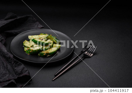 Delicious juicy cucumber cut into large slices with salt, spices and french mustard Delicious juicy cucumber cut into large slices with salt, spices and french mustard 104411917