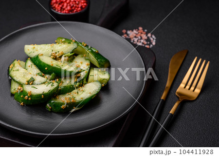 Delicious juicy cucumber cut into large slices with salt, spices and french mustard Delicious juicy cucumber cut into large slices with salt, spices and french mustard 104411928