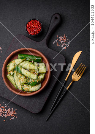 Delicious juicy cucumber cut into large slices with salt, spices and french mustard Delicious juicy cucumber cut into large slices with salt, spices and french mustard 104411932