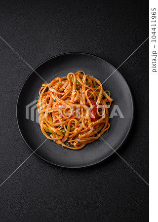 Delicious asian udon dish with vegetables, mushrooms, salt and spices 104411965