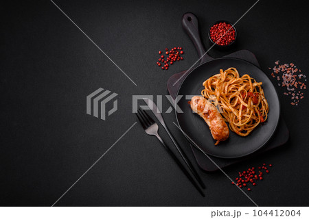 Delicious juicy grilled sausage with pasta or noodles with salt, spices and herbs 104412004