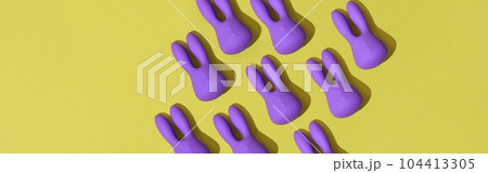 Many violet dildo vibrators for clitoris on yellow background. Sex toys for adult 104413305