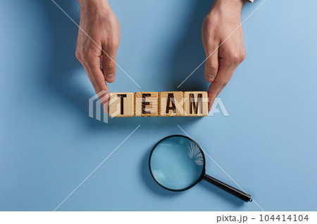 Wooden cubes with words TEAM, together everyone achieves more. Business, motivational and TEAM concept. 104414104