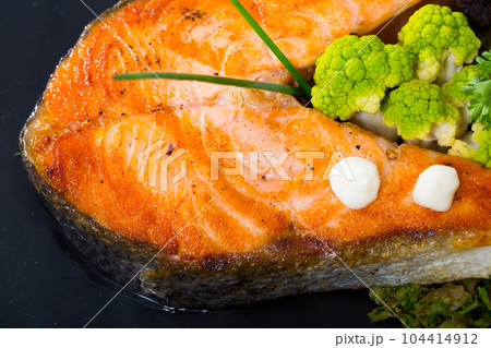 Cooked dish of tasty fried salmon with broccoli served on plate Cooked dish of tasty fried salmon with broccoli served on plate 104414912