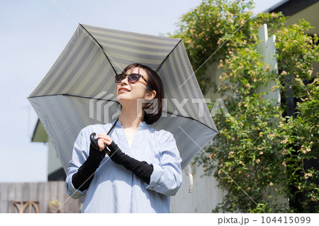 日傘をさす女性の写真 104415099