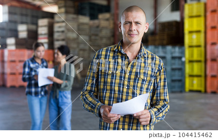 Confident male manager with documents inside large warehouse Confident male manager with documents inside large warehouse 104415462