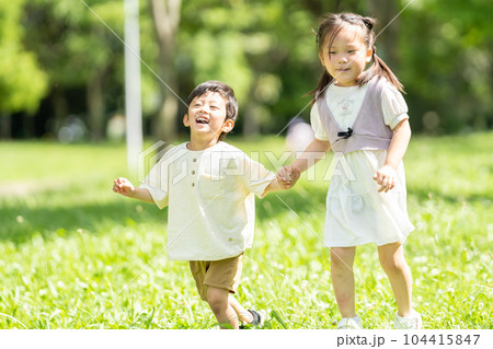 手をつないで走る男の子と女の子 104415847