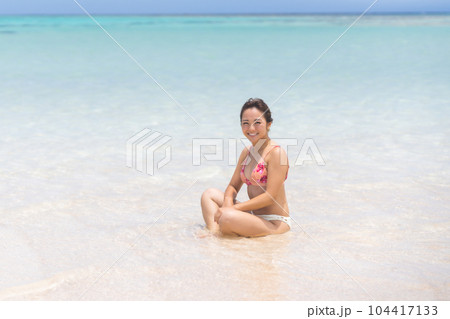 遠浅のビーチで微笑むビキニ姿の若い女性 104417133