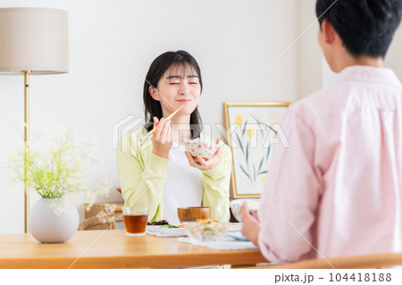 ダイニングでご飯を食べる若い夫婦 104418188