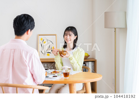 ダイニングでご飯を食べる若い夫婦 ダイニングでご飯を食べる若い夫婦 104418192