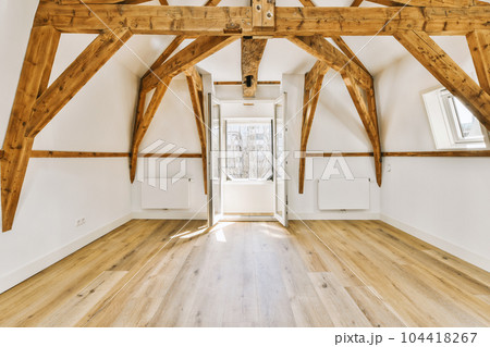 an empty room with wood floors and wooden beams on the ceiling, looking towards the entrance to the living room an empty room with wood floors and wooden beams on the ceiling, looking towards the entrance to the living room 104418267