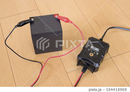12V鉛バッテリーと充電器 充電中の様子 12V鉛バッテリーと充電器 充電中の様子 104418908